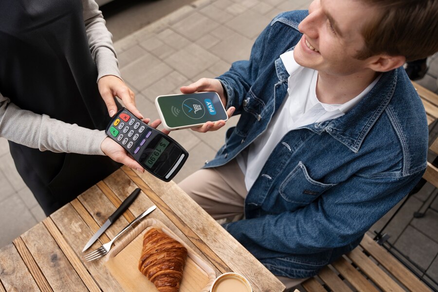 joven pagando con celular